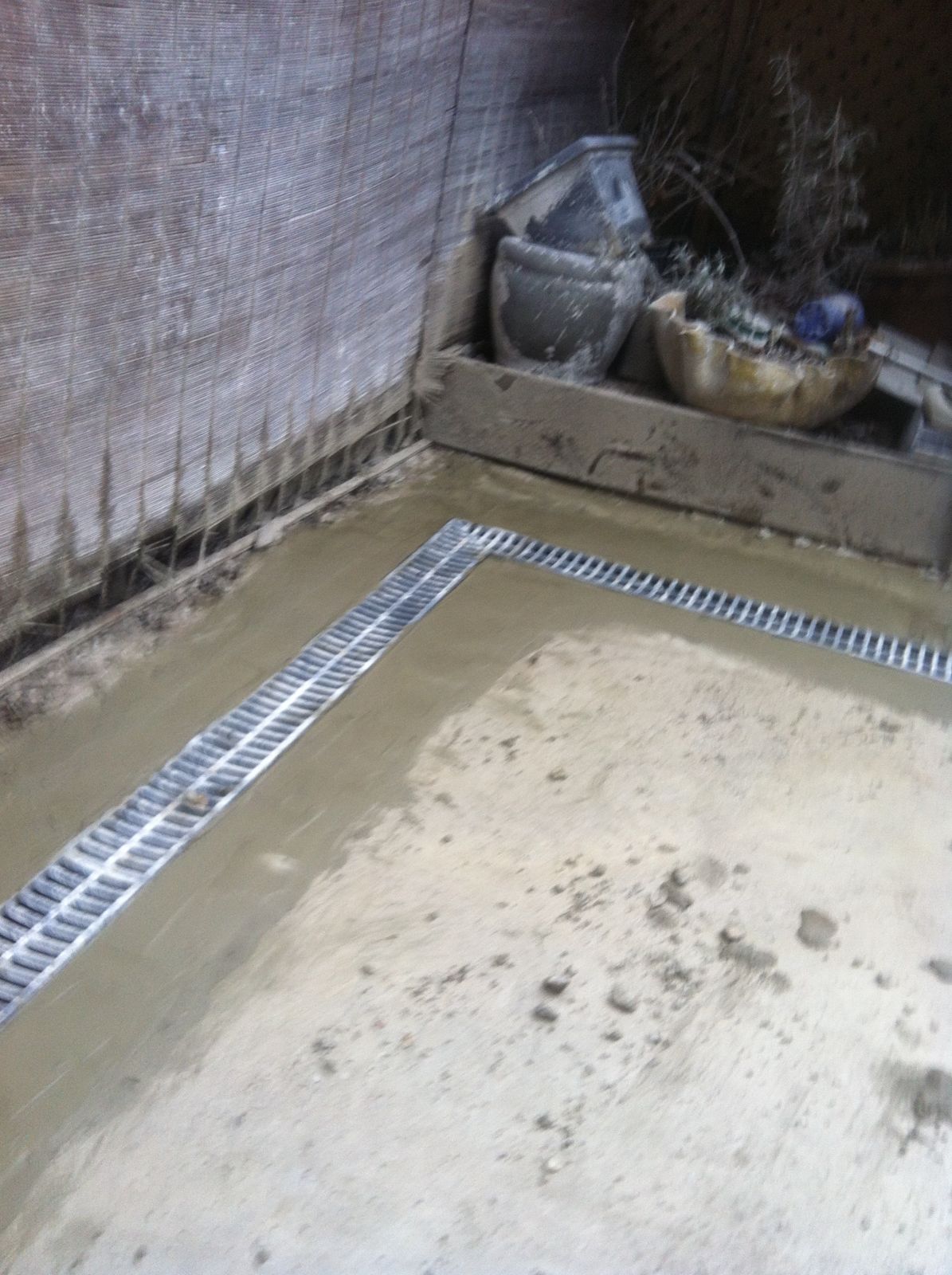 Metal trench drain grates set in freshly poured concrete