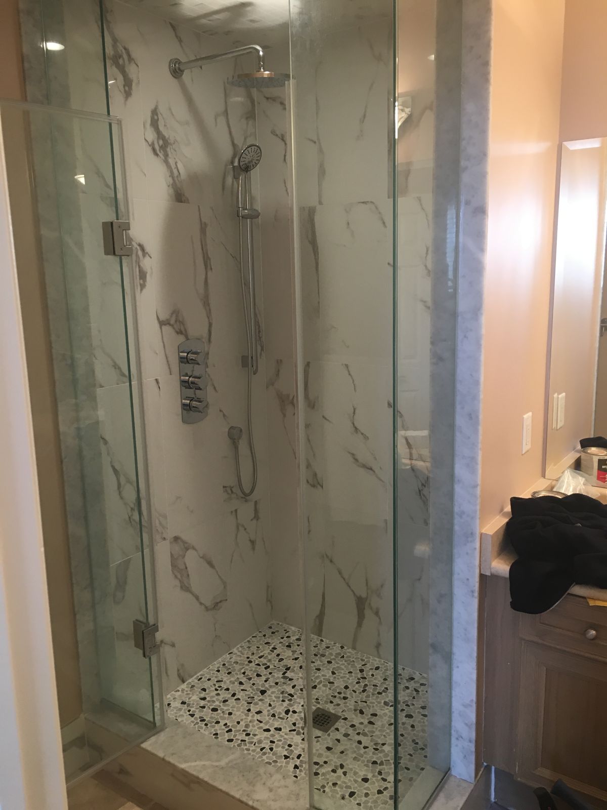 Finished walk-in shower with marble-look tile, glass enclosure and chrome thermostatic controls