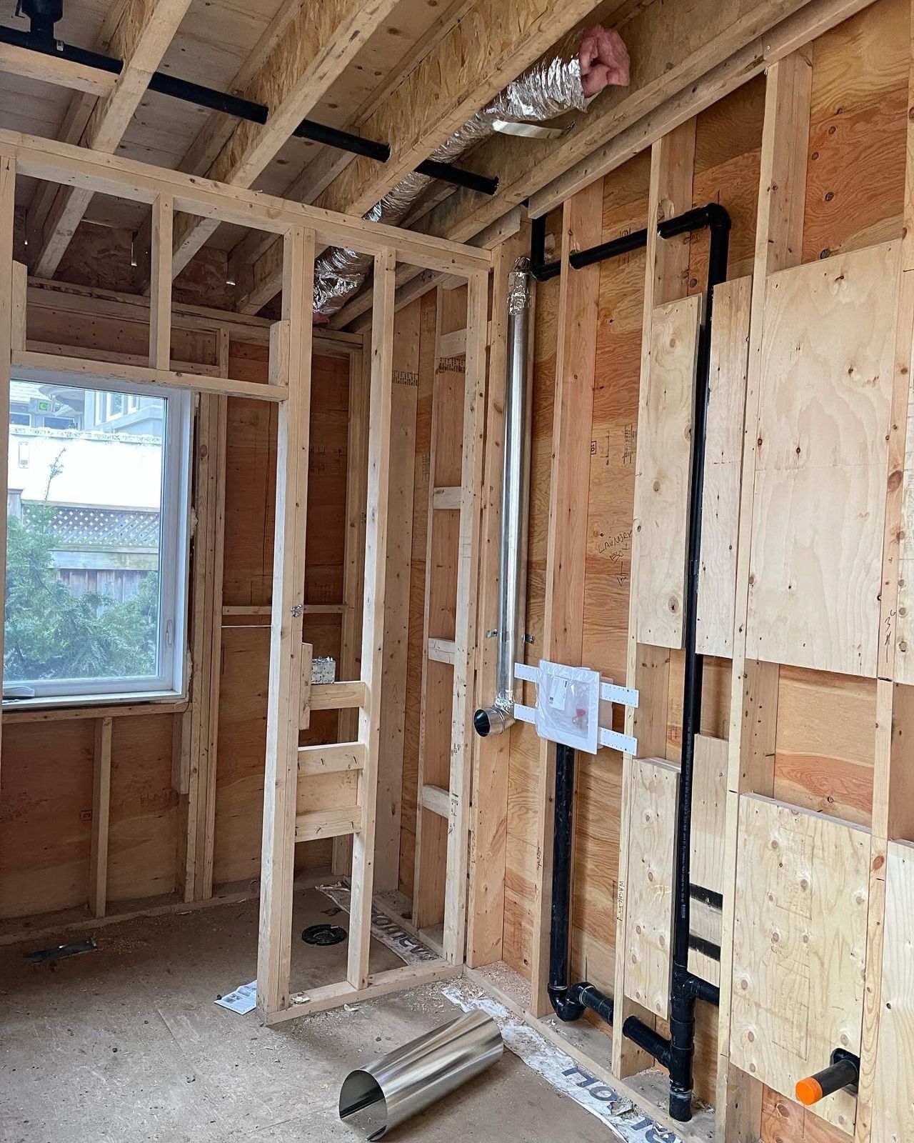 Black ABS drains and vents with a washer box roughed into a framed wall